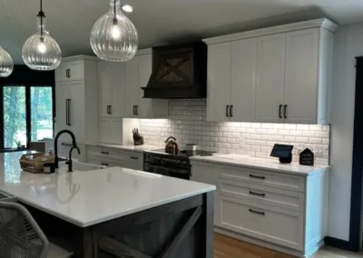 Modern kitchen with white cabinetry, subway tile backsplash, and a central island with pendant lighting.