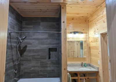 Modern bathroom with a walk-in shower and wood-paneled walls.